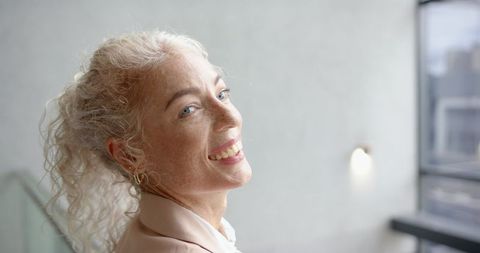 Cheerful Mature Woman Smiling with Curly Hair in Relaxed Mood