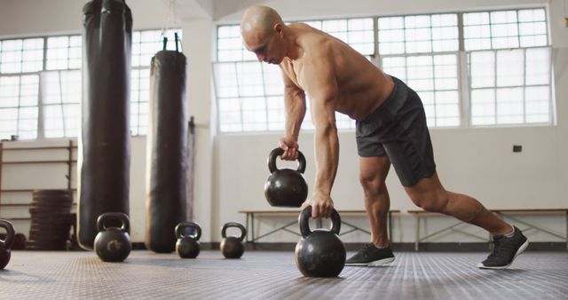 Bald Man Performing Kettlebell Exercise in Gym - Download Free Stock Photos Pikwizard.com