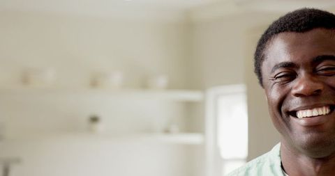 Smiling adult man in cozy kitchen with floating shelves