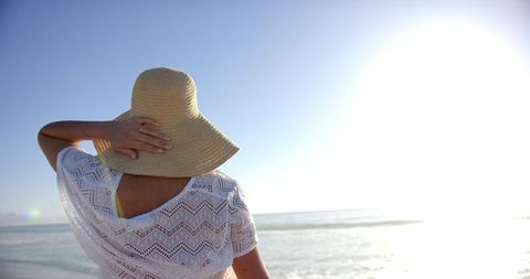 Woman Relaxing at Beach with Sun Hat and Ocean View
