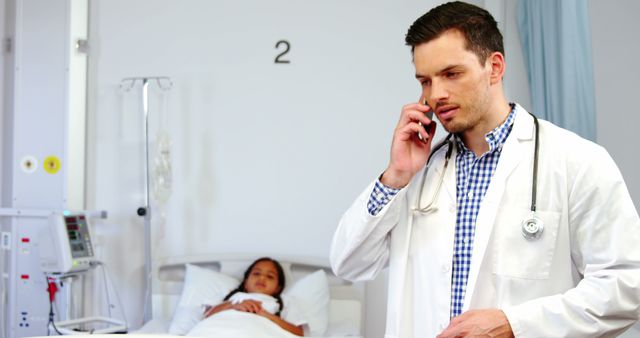 Doctor Taking a Phone Call Near Hospital Bed with Patient - Download Free Stock Images Pikwizard.com