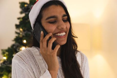 Woman in santa hat enjoying festive holiday call at home