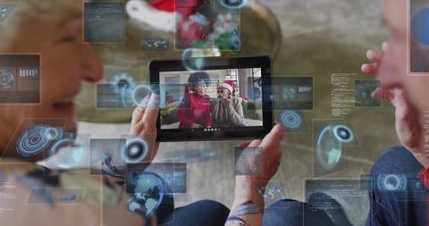 Senior couple videochatting with family during holiday using tablet and ar overlays