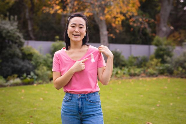 Smiling Asian Woman Showing Pink Ribbon for Cancer Awareness - Download Free Stock Photos Pikwizard.com