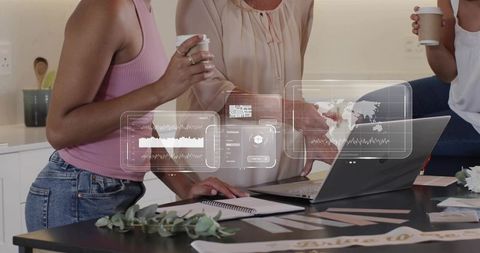 Colleagues Collaborating Over Laptop with Holographic Data Visualizations on Kitchen Island