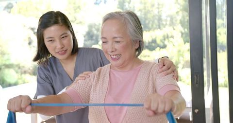Senior Asian Woman in Physiotherapy Session with Resistance Band