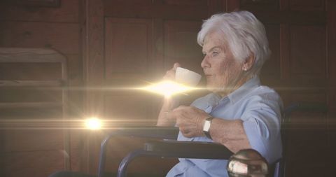 Senior Woman in Wheelchair Enjoying Morning Coffee with Sunbeams