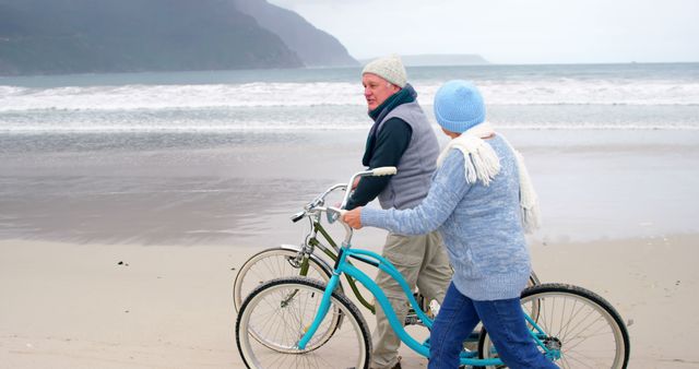 Senior Couple Strolling with Bicycles on Beach - Download Free Stock Images Pikwizard.com