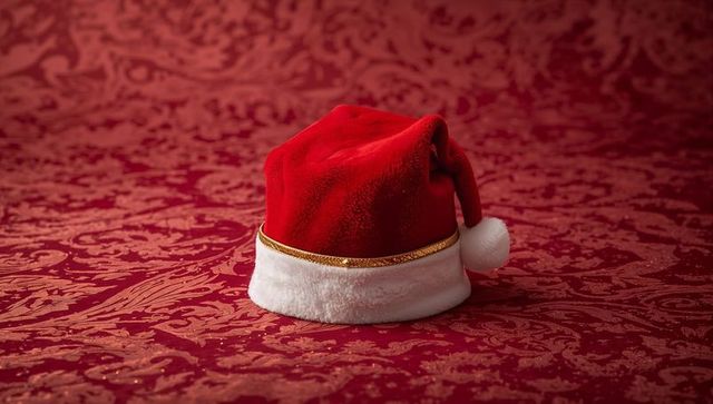 Velvet Santa Hat with Gold Trim on Red Damask Fabric for Festive Holiday Decor