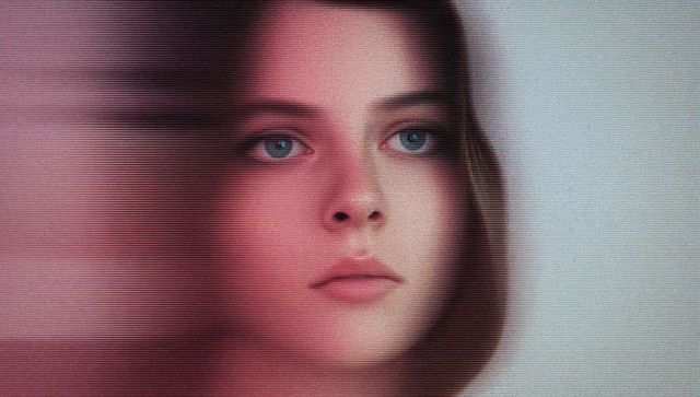 Distorted portrait of young woman with auburn hair and blue eyes