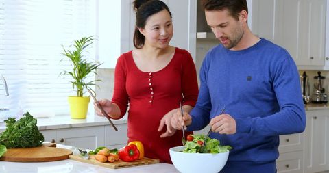 Couple Prepares Fresh Salad in Modern Kitchen Promoting Healthy Lifestyle