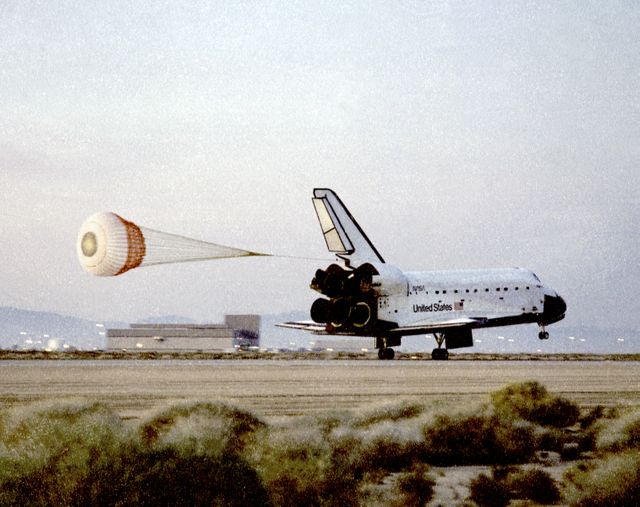 Space Shuttle Atlantis lands gracefully at Edwards Air Force Base, highlighting the end of a successful STS-76 mission. The deployed drag chute effectively aids in decelerating the shuttle upon touchdown on the runway. Photographs like these are valuable for historical records, educational content about space missions, and illustrating articles about significant achievements in space exploration. The photo captures the textures of the early morning environment and can be used for aerospace showcases and educational purposes.
