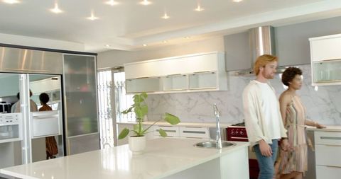 Happy couple touring modern kitchen with real estate agent