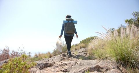 Eco-friendly traveler collecting litter on nature trail