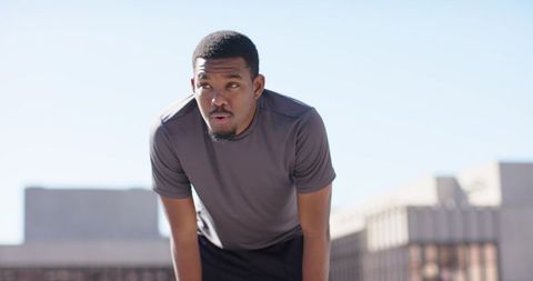 African American Athlete Breathing Hard After Rooftop Sprint, Urban Fitness Endurance Drill