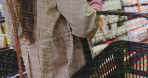 Shopper pushing cart in supermarket with data ticker overlay conveying retail analytics