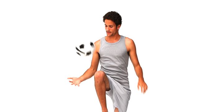 Young handsome man juggling soccer ball, dressed in casual athletic wear, isolated on white background. Ideal for sportswear advertisements, showcasing athletic skills, fitness motivations, and casual clothing designs.