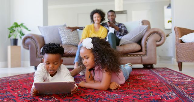 Parents Watching Kids Using Tablet on Red Rug in Living Room - Download Free Stock Images Pikwizard.com