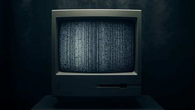 Retro CRT Monitor Displaying Static in Moody Ambient Room