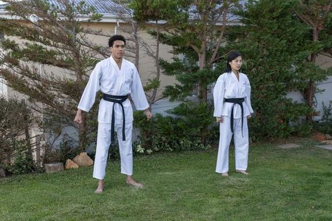 Karate Practice in Backyard with Diverse Athletes Wearing Black Belts