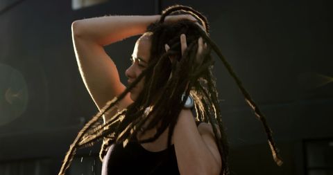 Young African American Woman Joyfully Shaking Her Dreadlocks Outdoors