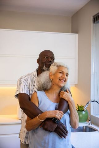 Loving Senior Couple Embracing in Modern Home Kitchen