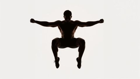 Shirtless Male Athlete Silhouette Leaping with Knees Tucked Minimal High-Key Composition