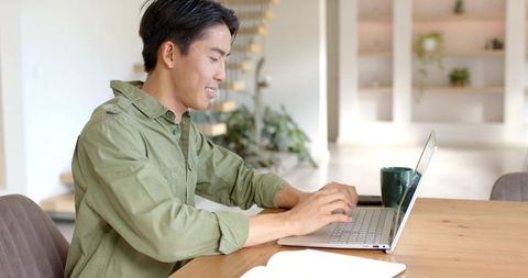 Relaxed Man Using Laptop in Contemporary Workspace