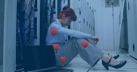 Stressed businesswoman in server room with heart illustrations