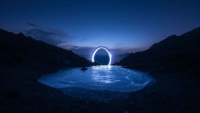 Glowing neon ring over frozen alpine basin reflecting blue light under starry night sky