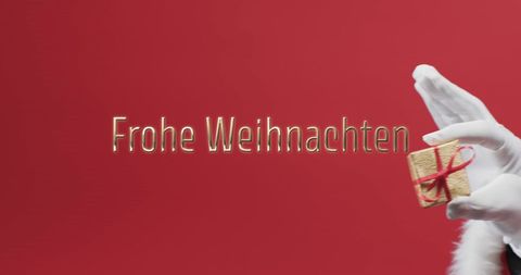 frohe weihnachten greeting with santa hand holding gift - Download Free Stock Images Pikwizard.com