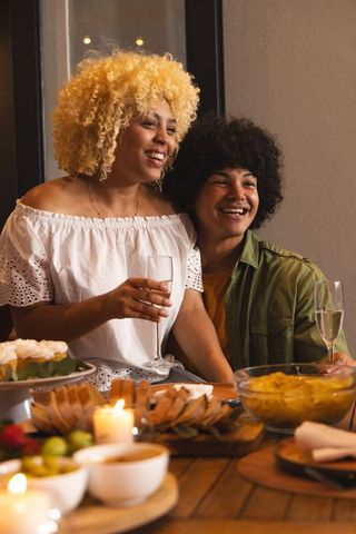 African american couple toasting at candlelit dinner, intimate cozy romance and celebration