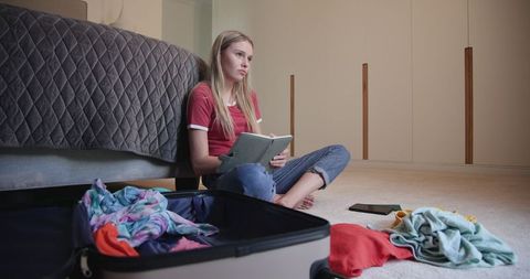 Teenage Girl Packing Bags Thoughtfully at Home for Trip