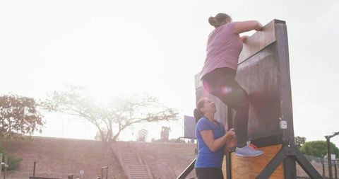 Women supporting each other during outdoor fitness challenge