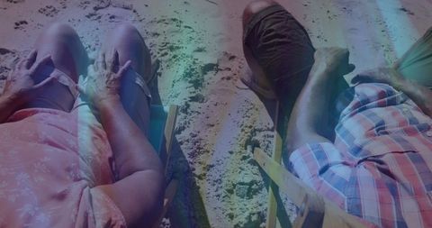 Relaxed seniors enjoying beach time with smartphone