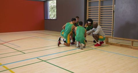 Coach leads team strategy session in sports hall