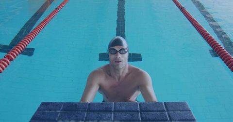 Competitive Swimmer Resting by Poolside with Swim Cap and Goggles