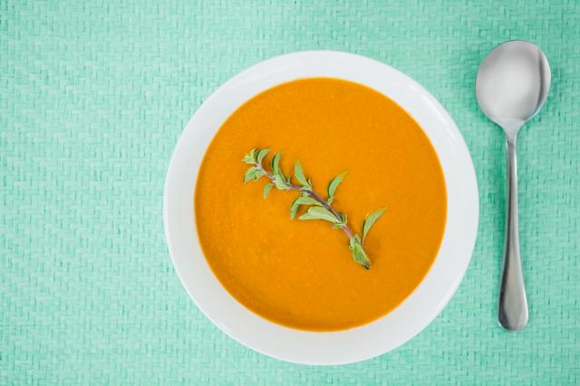 Bowl of pumpkin soup on tablecloth
