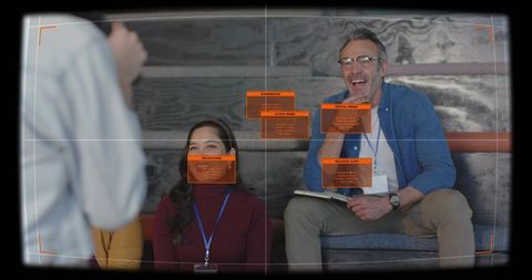 Panel speaker holding notebook while audience listening, cybersecurity hud overlay