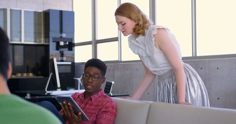 Young Colleagues Collaborating on Tablet in Modern Office