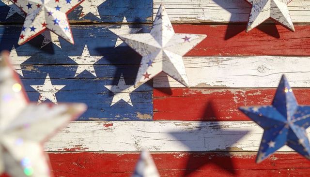 Rustic american flag with hanging 3d stars casting shadows on weathered wood