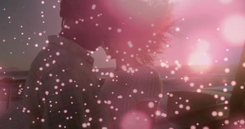 Sunset silhouette couple kissing on seaside with pink bokeh drift for romantic campaigns