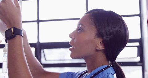Nurse Checking IV Drip Minority Healthcare Professional