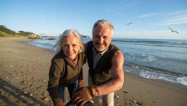 Senior couple smiling while cleaning beach during golden hour coastal cleanup activity