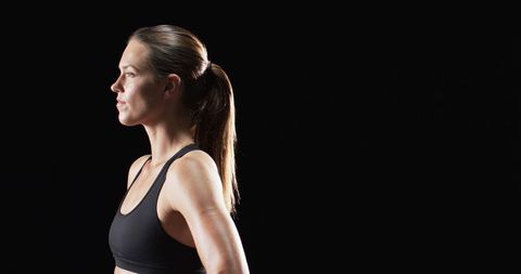Confident Athletic Woman Posing in Fitness Wear Against Dark Background - Download Free Stock Images Pikwizard.com