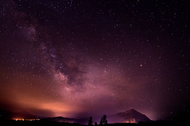 Scenic view of the Milky Way visible at night over a mountain range. Ideal for use in astronomy presentations, outdoor and nature-themed websites, and educational materials about space and astrophotography.