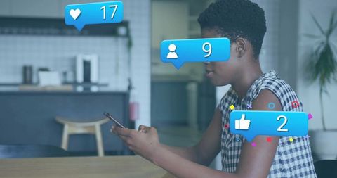 Woman viewing smartphone notifications in bright kitchen