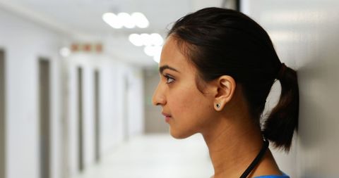 Thoughtful Young Woman Reflecting in Bright Corridor - Download Free Stock Images Pikwizard.com