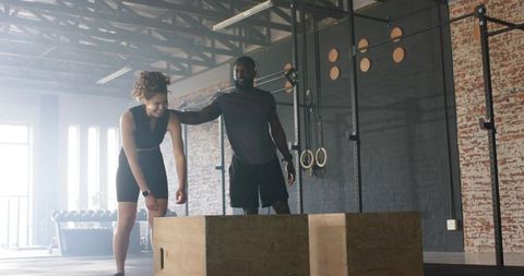Diverse fitness training with plyometric box in industrial gym