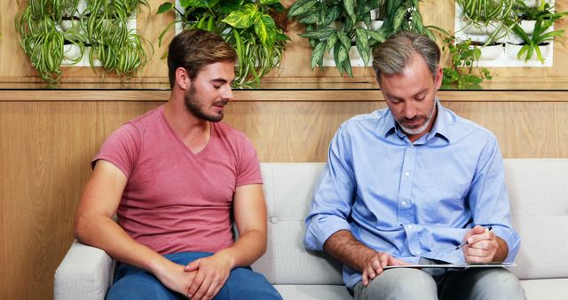 Therapist and Young Man Discussing Treatment in Office - Download Free Stock Images Pikwizard.com